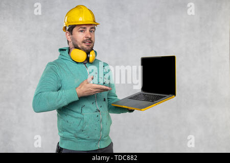 modern building supervisor keeps the computer in his hands, technology at work Stock Photo