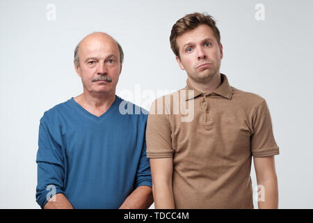 Two mature men father and son being sad. Stock Photo
