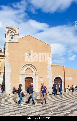 Taormina, Sicily, Italy - Apr 8th 2019: Vertical photo capturing tourists walking on the Piazza IX Aprile square in the city center. Italian Taormina is a famous tourist place. Sicilian city. Stock Photo