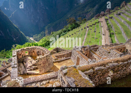Panoramic view on the ceremonial Temple of the Sun build by Incas on the Machu Picchu mountain. Archaeological site with green agricultural terraces. Stock Photo
