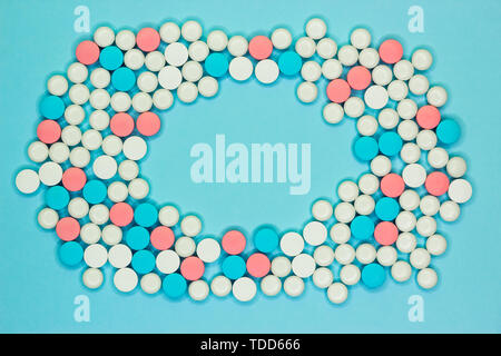 Frame made of white. blue and pink pills on color background, flat lay with space for text Stock Photo