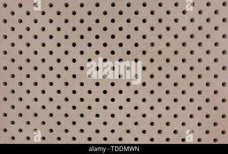 Concrete wall with small uniform drilled holes background Stock Photo