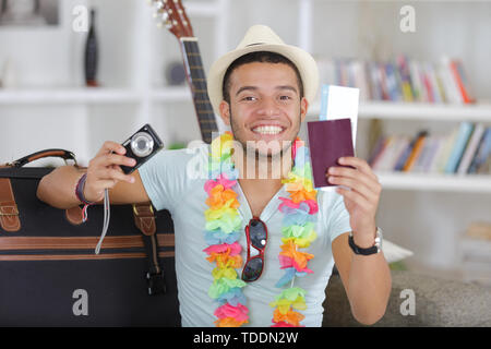 happy young vietnamese man with digital camera and passport Stock Photo