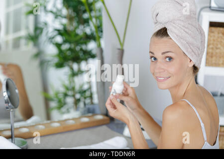 beautiful smiling woman applying cream Stock Photo