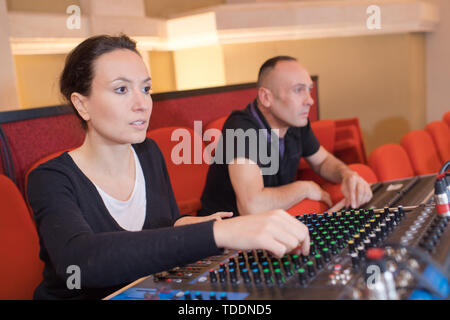 sound engineer working at mixing panel in boutique recording studio Stock Photo