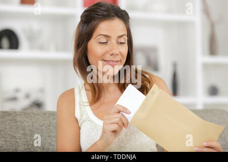 woman putting letter inside envelop Stock Photo