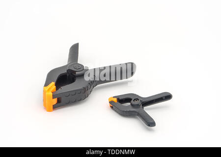 Black plastic clamps. Set of small and big size. Clamping equipment for handicraft, joinery and photography. White background. Stock Photo