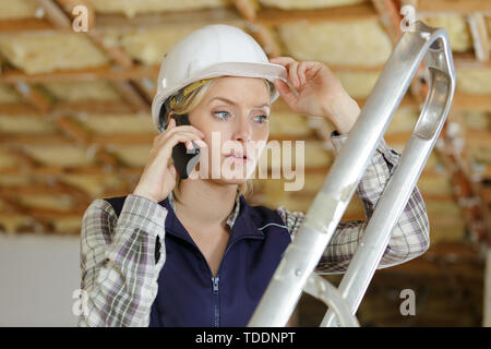 woman builder with blueprints using smart phone Stock Photo