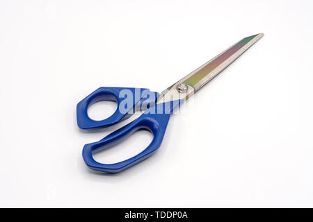 Metal tailor's scissors for sewing with blue large rings on a white background. Handicraft tool Stock Photo