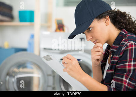 female plumber working on central heating boiler Stock Photo