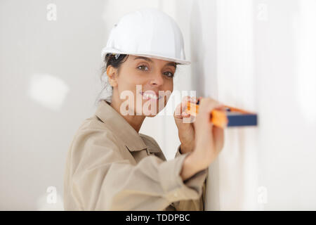 portrait of female builder using a spirit level Stock Photo