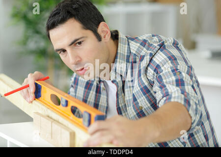 craftsman using spirit level on length of wood Stock Photo