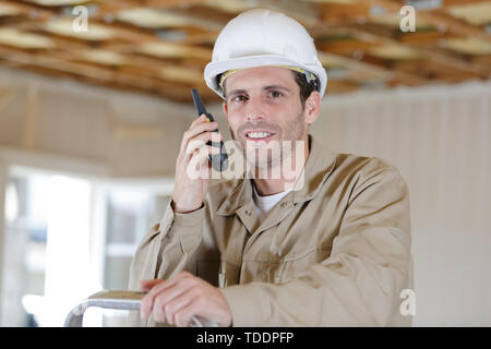 construction worker using walkie talkie indoors Stock Photo