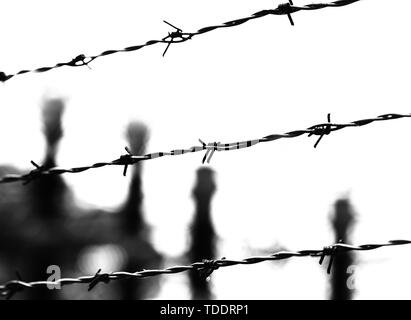 three barbed wires and blurred objects in black and white toned effect Stock Photo