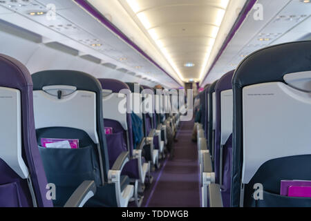 Airplane seats in the cabin economy class and the windows of the airplane. A view of porthole window on board an airbus for your travel concept or pas Stock Photo
