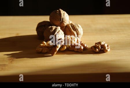 Walnuts on wooden board. Nuts in the shell on wood. Natural and healthy autumns food. Stock Photo