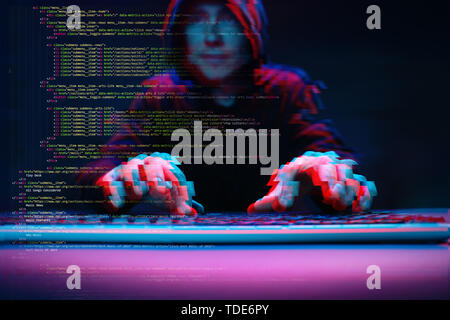 Hacker working with computer in dark room with digital interface around. Image with glitch effect. Stock Photo