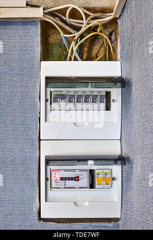 Electrical safety in houses, modern electrical switchboard, fusebox, new electronic electricity meter and old burned problem wiring. Burned out wires  Stock Photo
