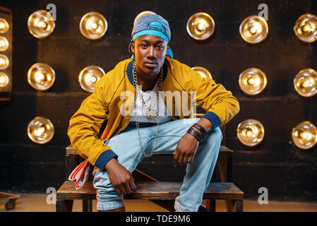Black rapper in cap sitting on the steps Stock Photo