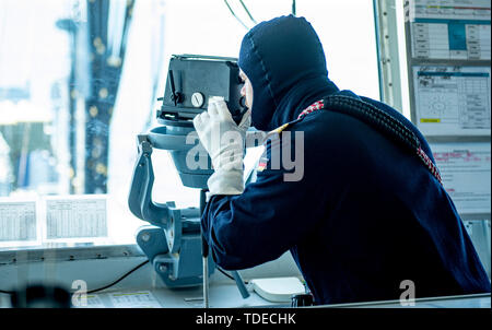 Bornholm, Denmark. 14th June, 2019. A marinesoldier in combat uniform works on the bridge of the 'Bonn' task force supply company, which operates near the Danish island of Bornholm. The ship of the German Navy takes part in the Nato manoeuvre 'Baltops' on the Baltic Sea. Credit: Axel Heimken/dpa/Alamy Live News Stock Photo