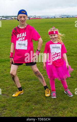 Baiter Park, Poole, Dorset, UK. 15th June 2019. Cold wet day for Race for Life Pretty Muddy Kids where children can join in the fight to beat cancer and raise money for Cancer Research UK. Children over 1.2m tall and up to 12 years of age, accompanied by an adult, negotiate obstacles throughout the course which is up to 5km and have fun getting covered in mud. Mudders Tegan and Rosalie (permission received). Credit: Carolyn Jenkins/Alamy Live News Stock Photo
