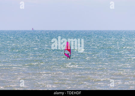 Camber, East Sussex, UK. 15th June, 2019. UK Weather: A beautiful sunny start to the weekend in Camber, East Sussex as people arrive to the Camber Sands beach to enjoy the warm weather. A solitary wind surfer with a bright pink sail takes to the sea on a warm and pleasant day with a slight breeze in the air. Credit: Paul Lawrenson 2019, Photo Credit: Paul Lawrenson/ Alamy Live News Stock Photo