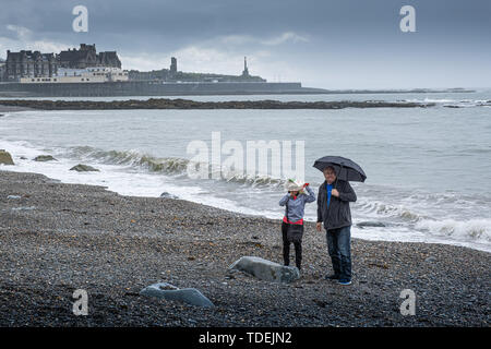 Aberystwyth Wales UK, Saturday 15th June 2019  UK Weather: A couple have the beach to themselves on a grey and wet afternoon at the seaside in Aberystwyth , west wales, as the dreary wet and very unsesonal June ‘summer’ weather continues its hold on the country  photo credit Keith Morris / Alamy Live News Stock Photo