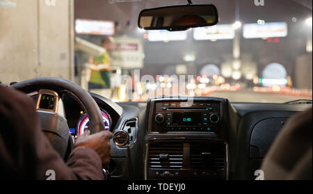 Driving in New York at night. Interior view of taxi cab. Close up view on the dashboard and drivers hand. Stock Photo