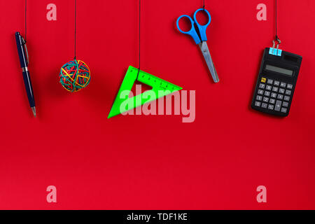 School supplies hang on the rope. School supplies on red background. Back to school concept Stock Photo