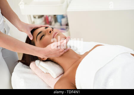 Woman receiving head massage in spa wellness center. Stock Photo