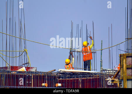 Construction workers working on a building column. Stock Photo