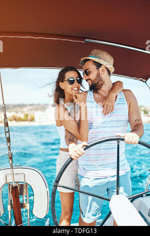 Beautiful young couple of lovers sailing on a boat Stock Photo