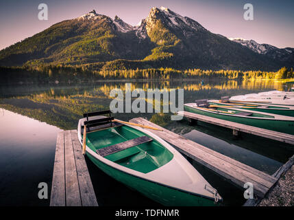 Morning scenery with boats moored on Hintersee lake at sunrise, Bavaria, Germany in summer