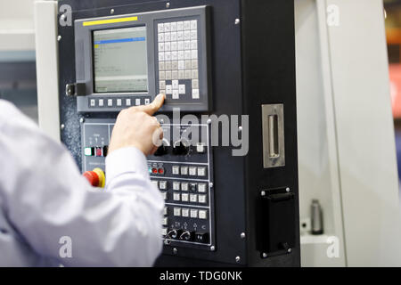 CNC machine operator working with a control panel. Selective focus. Stock Photo