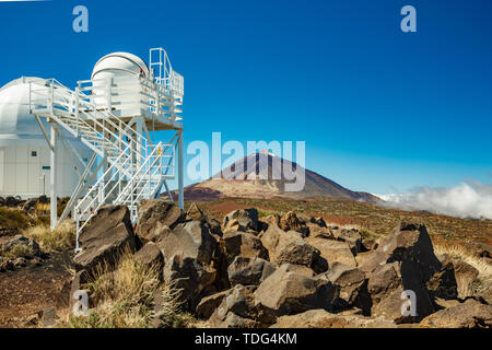 International observatory in Teide National Park. Volcano Teide on the backgriund. Windy day with clouds and amazinc colors. Technology science concep Stock Photo