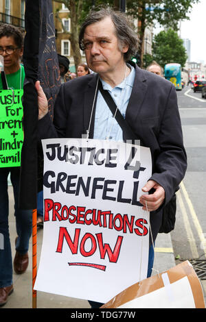 A campaigner holds a placard during the Justice for Grenfell Solidarity rally against the lack of action by the Government following the Grenfell Tower fire, in rehousing affected families, delays in the Public Inquiry, tower blocks still covered in flammable cladding, soil contamination and the performance of Royal Borough of Kensington and Chelsea. On 14 June 2017, just before 1:00 am a fire broke out in the kitchen of the fourth floor flat at the 24-storey residential tower block in North Kensington, West London, which took the lives of 72 people. More than 70 others were injured and 223 pe Stock Photo