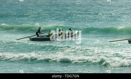 ALEXANDRA HEADLAND, QUEENSLAND, AUSTRALIA- APRIL 21, 2016: backlit shot of surf boats battling waves in a race on the sunshine coast of australia Stock Photo