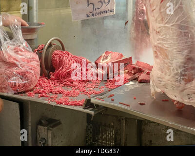 a butcher grinds miced meat at athens central market in greece Stock Photo