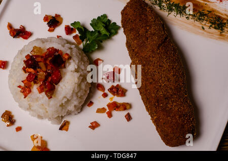 Tasty seasoned fried pork chops cooked in a spicy marinade are served with boiled potatoes, salads and sauces. Cutlets on a plate on a wooden table to Stock Photo