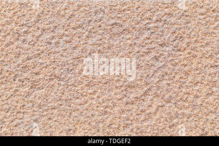 Close-up of a bumpy red granite stone wall. High resolution full frame background texture. Stock Photo