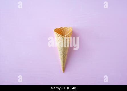 Empty waffle cone on pink background. Creative design. Stock Photo