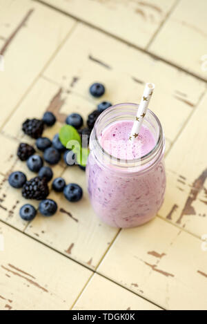 Blueberry smoothie in bottle on wooden background. Top view, vertical orientation. Concept of clean eating Stock Photo