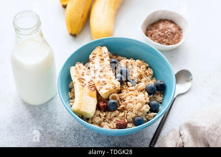 Oatmeal porridge with banana, blueberry, nuts and bottle of milk. Healthy breakfast food Stock Photo