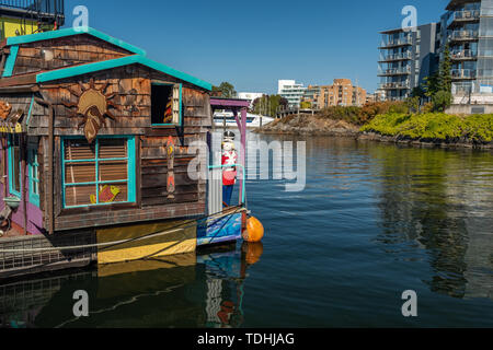 Victoria, Vancouver Island, British Columbia, Canada, July, 8, 2018: The floating homes in Victoria against a backdrop of a modern apartment block. Stock Photo