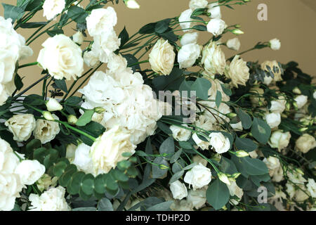Decoration of the banquet hall, photo zone and wedding arch with eucalyptus leaves, hydrangea and eustoma in the wedding hall. Golden branches. Weddin Stock Photo