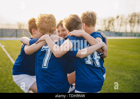 Group of friends happy kids in school sports team. Boys gathering and having fun on sports field. Cheerful children boys players of school soccer team Stock Photo