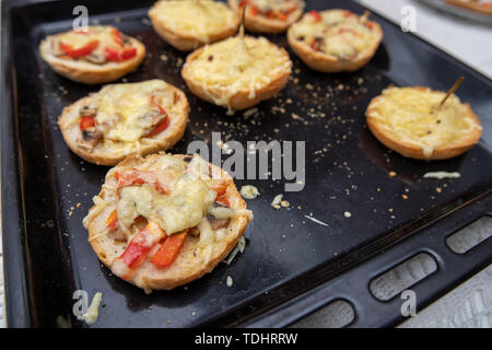 Tasty casserole with cheese on a baking tray from the oven. A fresh meal prepared in a home kitchen. dark background. Stock Photo