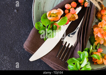 Vintage table setting with delicate flowers on a linen napkin on on rustic shabby table, close-up. Holiday Table Set with floral decor Stock Photo