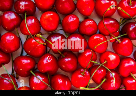 Sweet cherries top view background. Juicy summer red berries backdrop. Sugar containing fruit, summer harvest from above. Fresh vegetarian nutrient, vitamin source, delicious dessert closeup Stock Photo