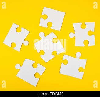 blank white big puzzles on yellow background, flat lay Stock Photo
